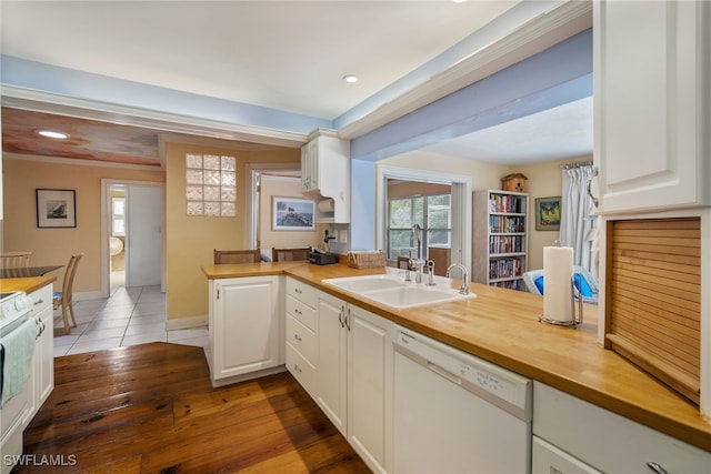 kitchen with white cabinetry, sink, wooden counters, kitchen peninsula, and white dishwasher