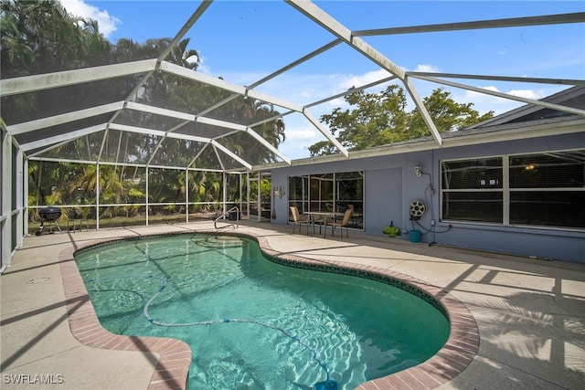 view of swimming pool featuring glass enclosure and a patio