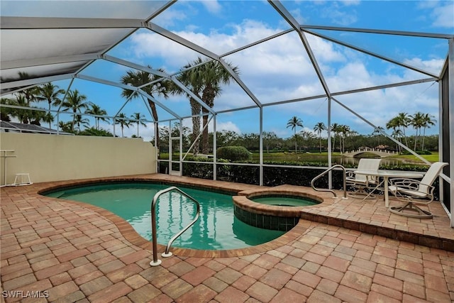 view of pool featuring an in ground hot tub, glass enclosure, and a patio area