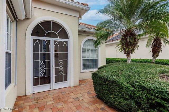 view of exterior entry featuring a patio area