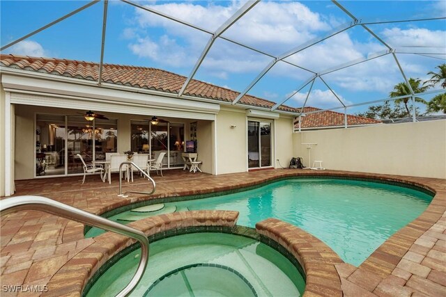 view of pool with a patio, ceiling fan, an in ground hot tub, and glass enclosure