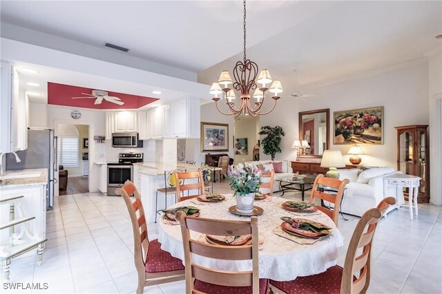 tiled dining space with ceiling fan with notable chandelier