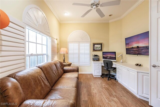 home office with ceiling fan, light hardwood / wood-style flooring, built in desk, and crown molding