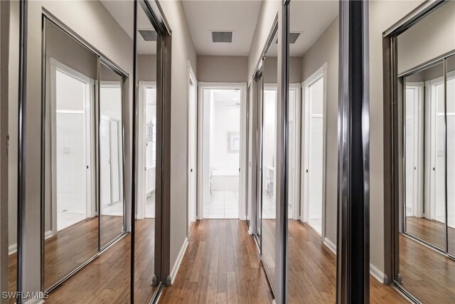 hallway with hardwood / wood-style flooring