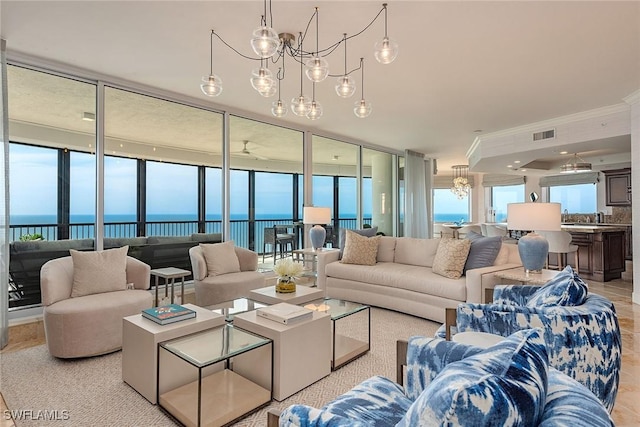 living room with ceiling fan with notable chandelier, a healthy amount of sunlight, a water view, and a wall of windows