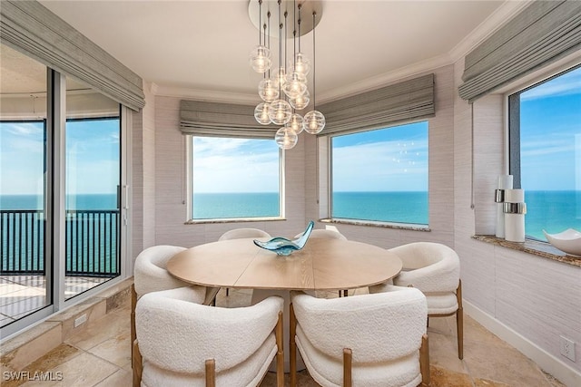 dining space featuring light tile patterned flooring, a water view, crown molding, and tile walls