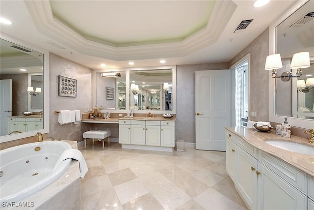 bathroom featuring vanity, a tray ceiling, crown molding, and tiled tub