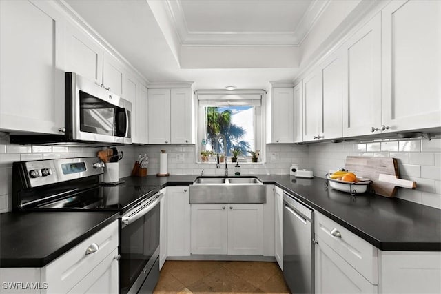 kitchen featuring white cabinets, decorative backsplash, stainless steel appliances, and ornamental molding