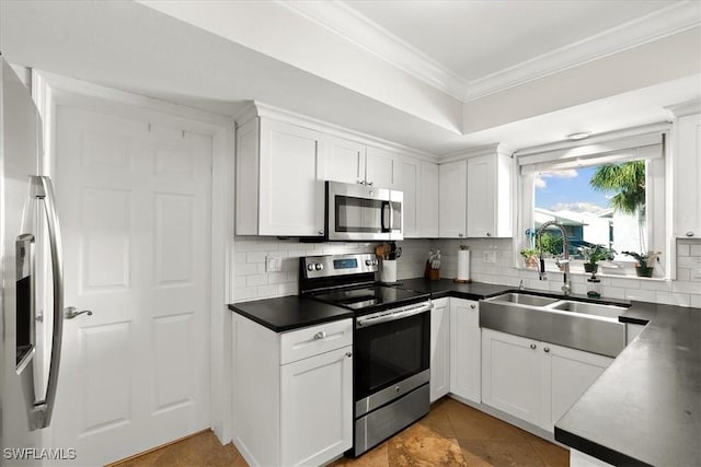 kitchen featuring white cabinetry, stainless steel appliances, decorative backsplash, crown molding, and sink