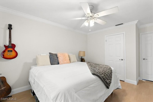 bedroom with ceiling fan, light wood-type flooring, and ornamental molding