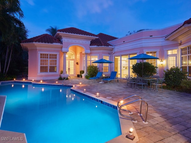 pool at dusk with a patio