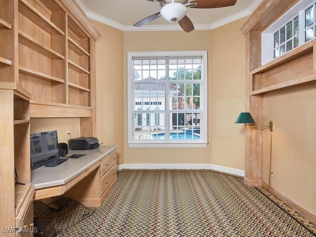 office with crown molding, built in desk, and ceiling fan