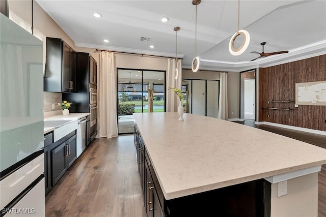 kitchen with ceiling fan, stainless steel dishwasher, pendant lighting, wooden walls, and a kitchen island