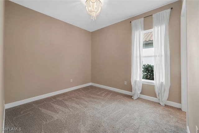 unfurnished room with carpet and a notable chandelier