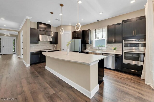 kitchen with pendant lighting, dark hardwood / wood-style flooring, stainless steel appliances, and a center island