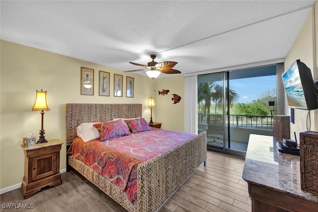 bedroom with expansive windows, a textured ceiling, access to outside, ceiling fan, and hardwood / wood-style flooring