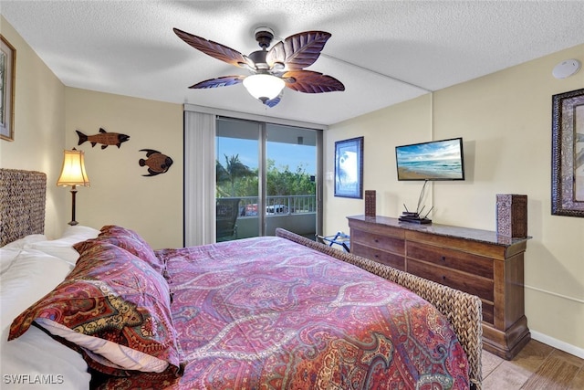 bedroom featuring ceiling fan, access to exterior, and a textured ceiling