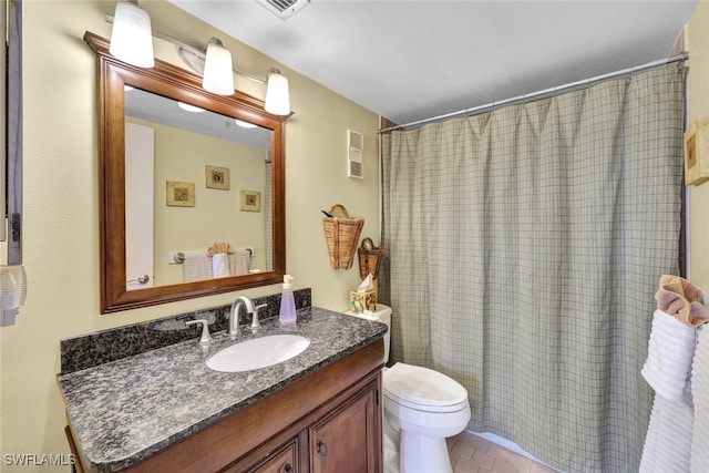 bathroom with tile patterned flooring, vanity, toilet, and walk in shower