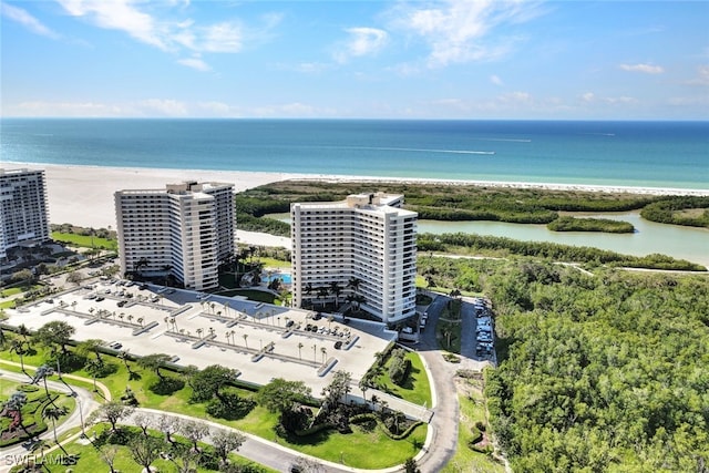 birds eye view of property with a water view and a beach view