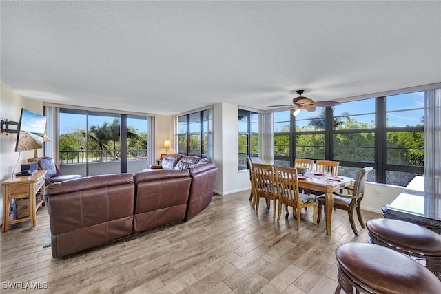 living room with a healthy amount of sunlight, ceiling fan, light hardwood / wood-style floors, and a textured ceiling