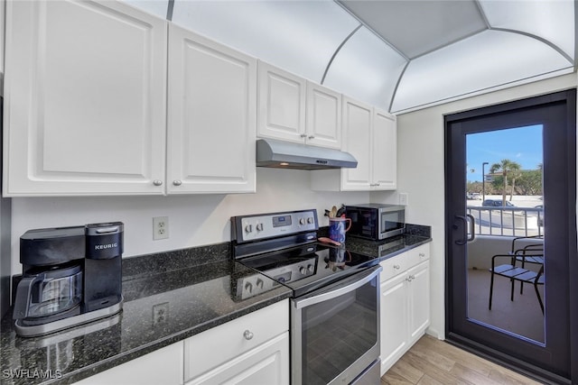 kitchen featuring white cabinets, light hardwood / wood-style floors, dark stone countertops, and stainless steel appliances