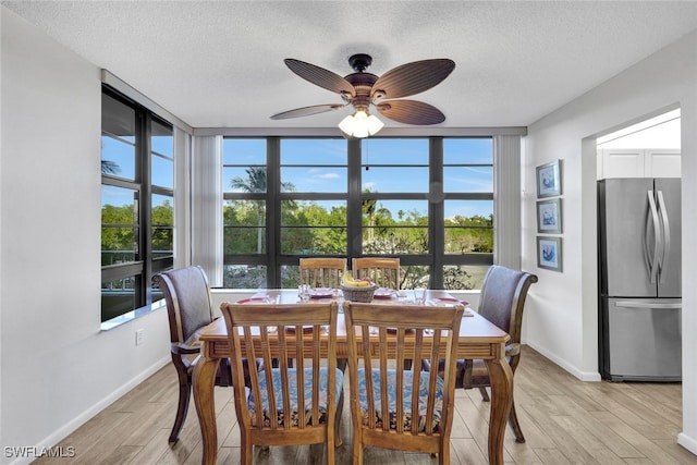 dining room with ceiling fan, light hardwood / wood-style flooring, and a textured ceiling