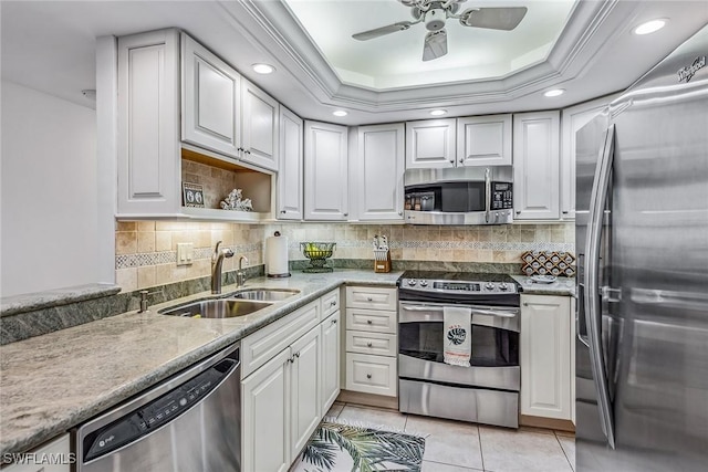 kitchen with white cabinets, appliances with stainless steel finishes, a raised ceiling, and sink