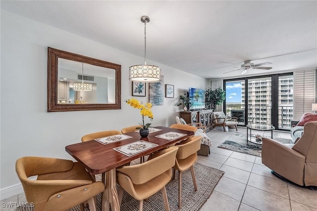 dining space with ceiling fan, light tile patterned floors, and a wall of windows