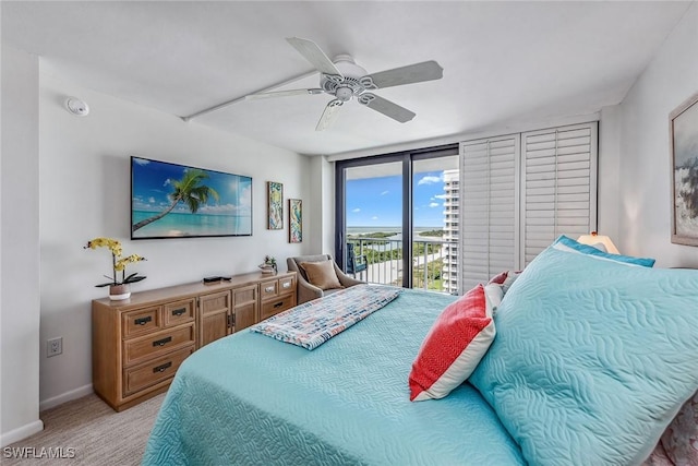 carpeted bedroom with access to outside, ceiling fan, and a wall of windows