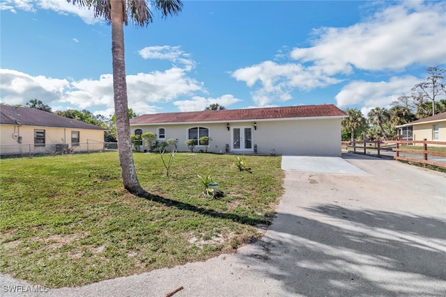 ranch-style home featuring french doors and a front lawn