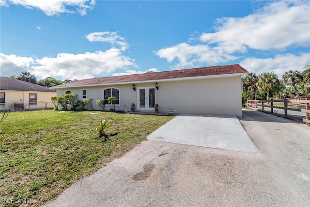 ranch-style home with a front lawn and french doors