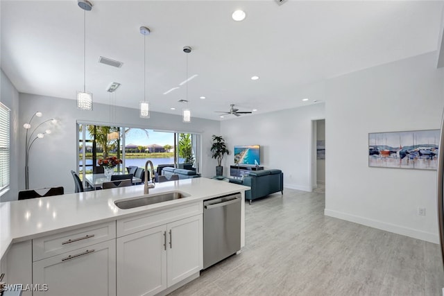 12418 Dahlia Ct, Naples, FL 34120 - kitchen with stainless steel dishwasher, a sink, white cabinets, pendant lighting, and light countertops