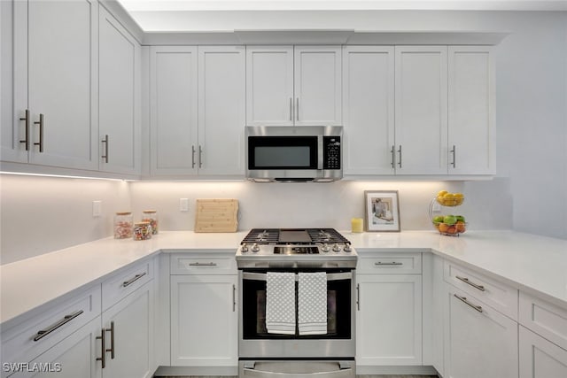 12418 Dahlia Ct, Naples, FL 34120 - kitchen featuring stainless steel appliances, light countertops, and white cabinetry