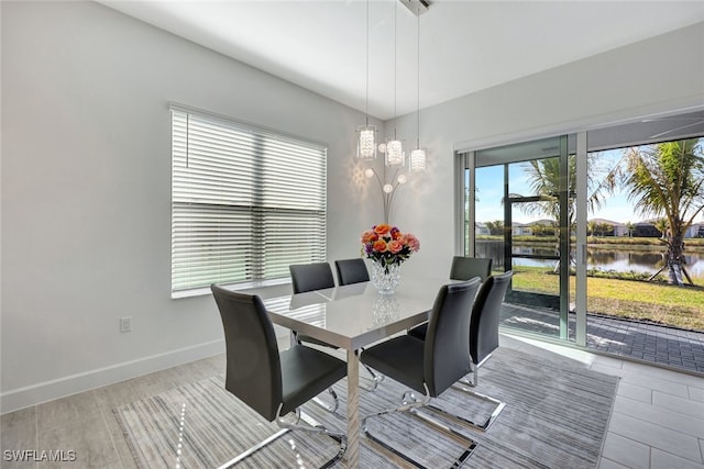 dining area with a water view and light hardwood / wood-style floors