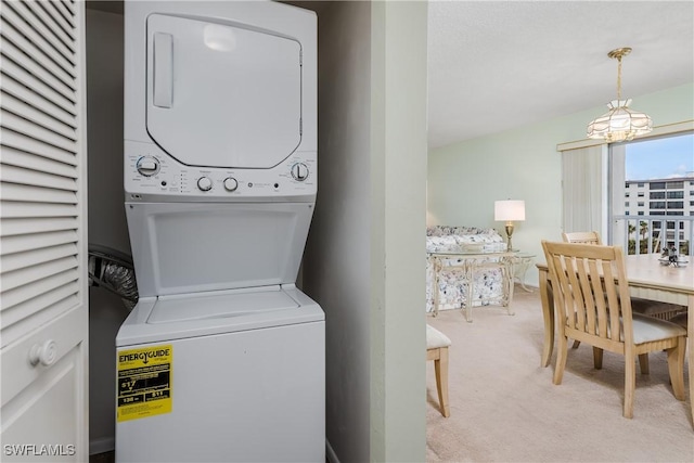 laundry room featuring stacked washer and dryer and light colored carpet