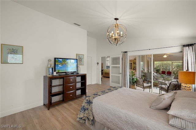 bedroom featuring a high ceiling, access to exterior, a notable chandelier, and light hardwood / wood-style flooring