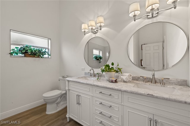 bathroom with toilet, hardwood / wood-style floors, and vanity