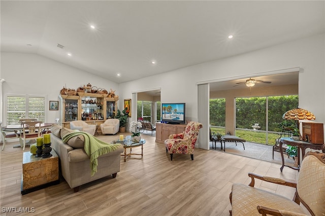 living room featuring ceiling fan, light wood-type flooring, and vaulted ceiling