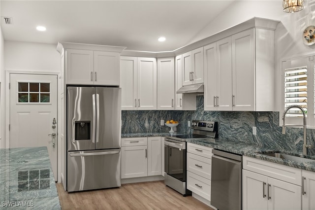 kitchen with light wood-type flooring, appliances with stainless steel finishes, white cabinetry, and sink