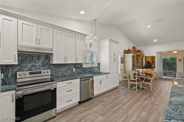 kitchen featuring vaulted ceiling, decorative light fixtures, white cabinetry, appliances with stainless steel finishes, and sink