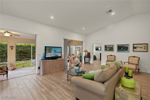 living room with lofted ceiling, ceiling fan, and light hardwood / wood-style floors