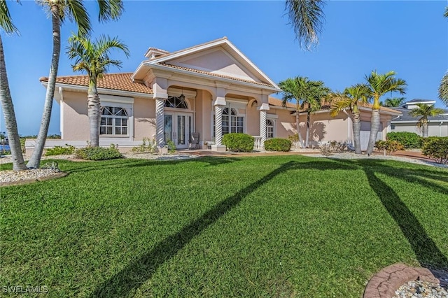 view of front of home with a front yard, french doors, and stucco siding