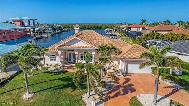 view of front facade featuring a garage, a tiled roof, french doors, and a water view