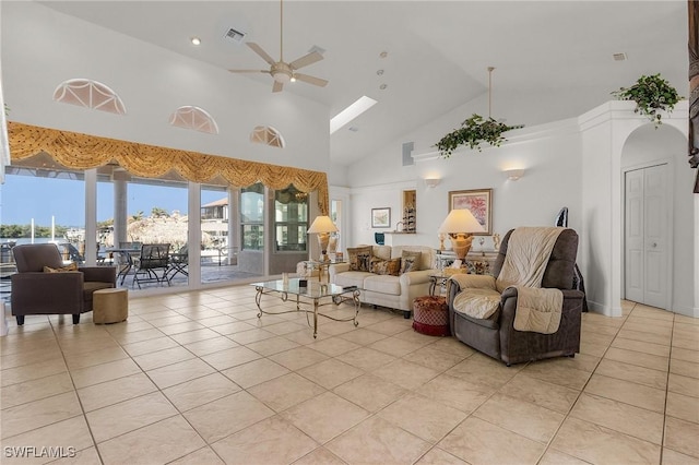 tiled living room with ceiling fan and high vaulted ceiling