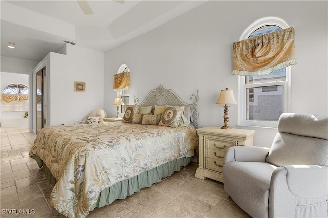 bedroom featuring ensuite bath, ceiling fan, and multiple windows