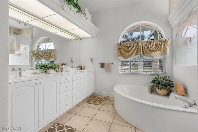 bathroom featuring tile patterned floors, plenty of natural light, vanity, and a washtub