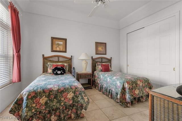 tiled bedroom with ceiling fan and a closet