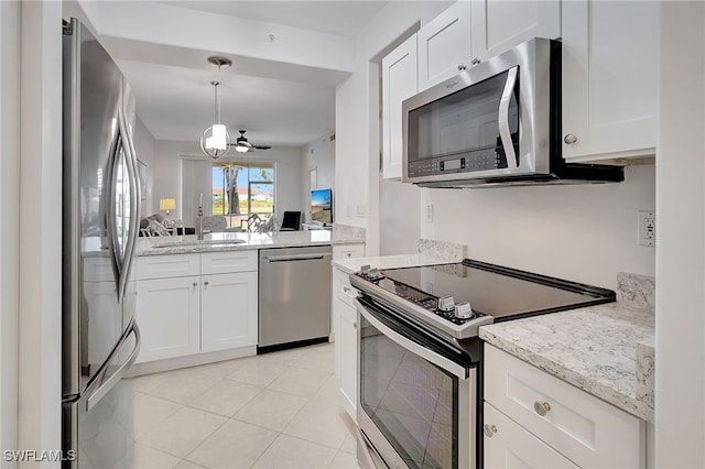 kitchen featuring white cabinets, ceiling fan, light tile patterned floors, appliances with stainless steel finishes, and light stone counters