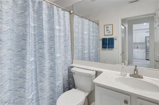 bathroom featuring a shower with curtain, vanity, and toilet