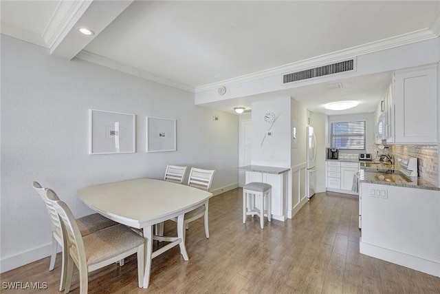 dining room featuring ornamental molding and hardwood / wood-style floors